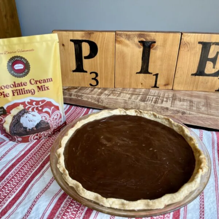 The chocolate cream pie mix pouch beside a finished pie and PIE letter blocks